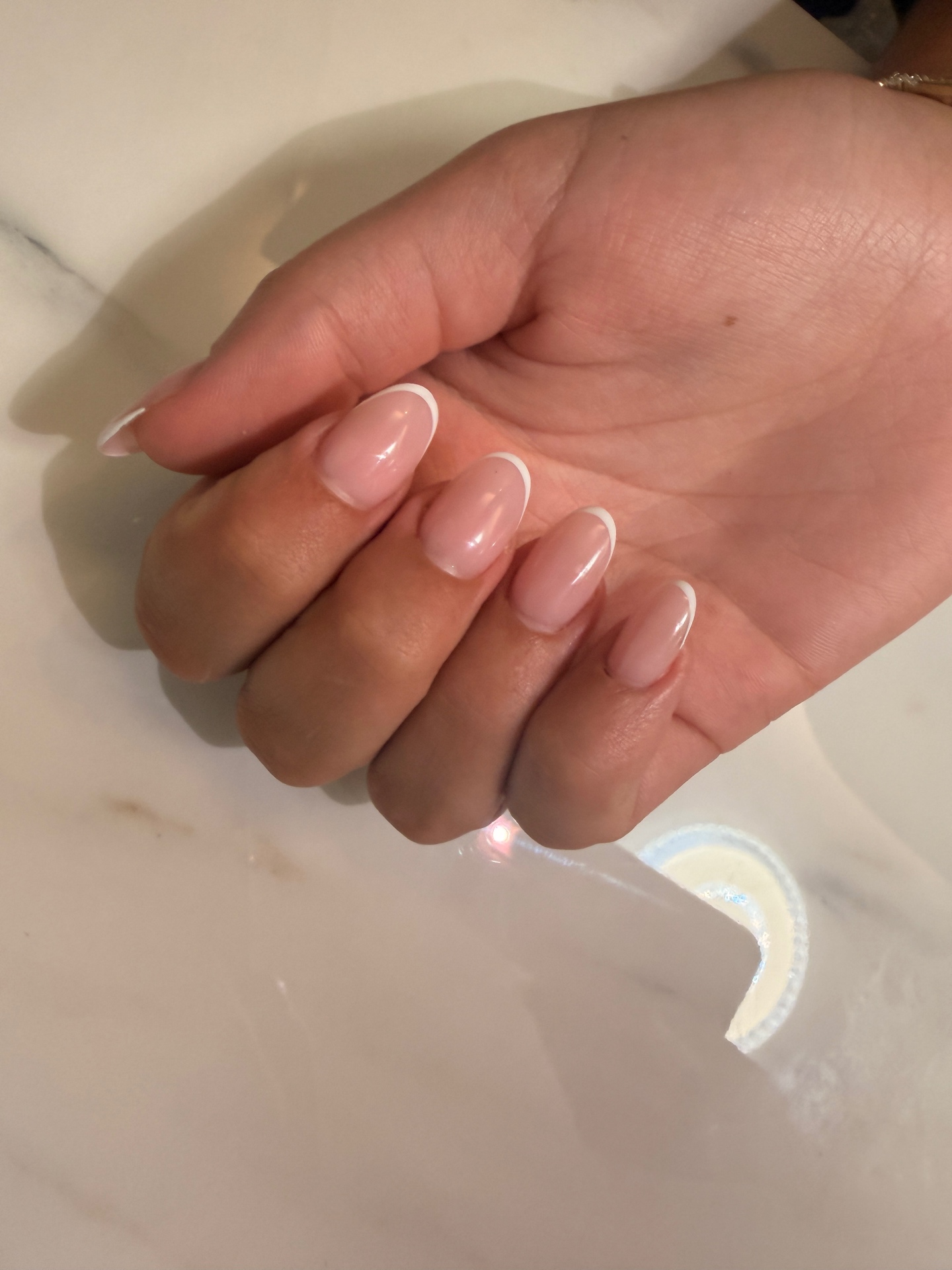 Manucure russe avec pose french blanche sur ongles amande, fini nude brillant